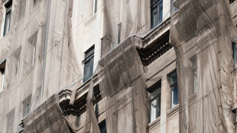 Imagen de la fachada de un edificio recubierta con una red de seguridad